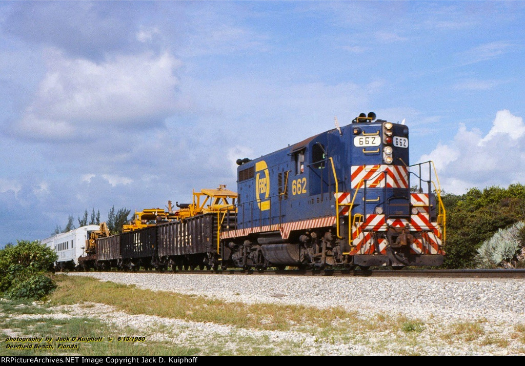 Florida East Coast, FEC GP9 662, is northbound with white flags flying on a work extra, at Deerfield Beach, Florida.  June 13, 1980. 